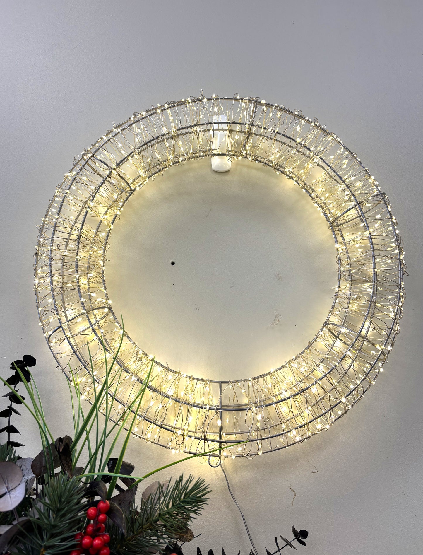 Decorative light fixture with fairy lights on a plain wall