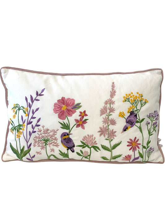 Decorative pillow with floral and bird embroidery on a textured surface