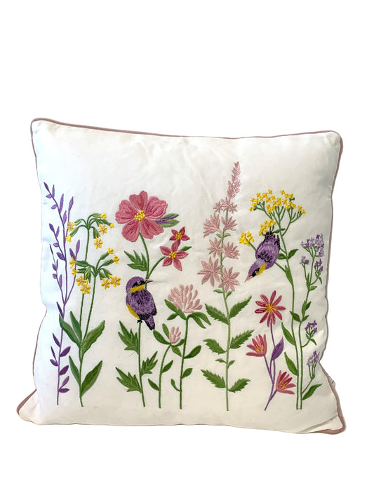 Decorative pillow with floral and bird embroidery on a white background