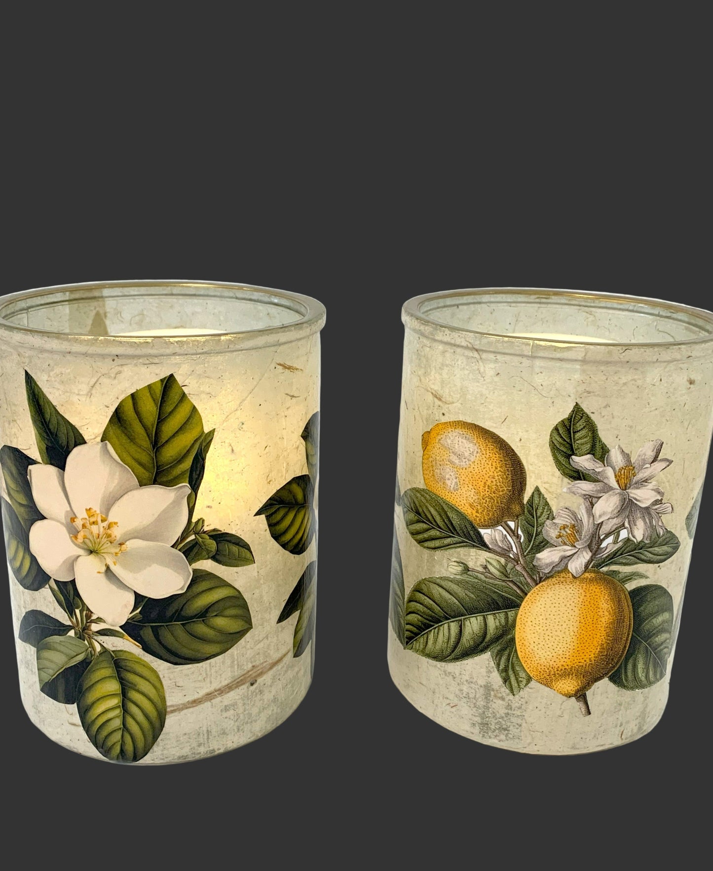 Two candle holders with floral and lemon designs on a white background