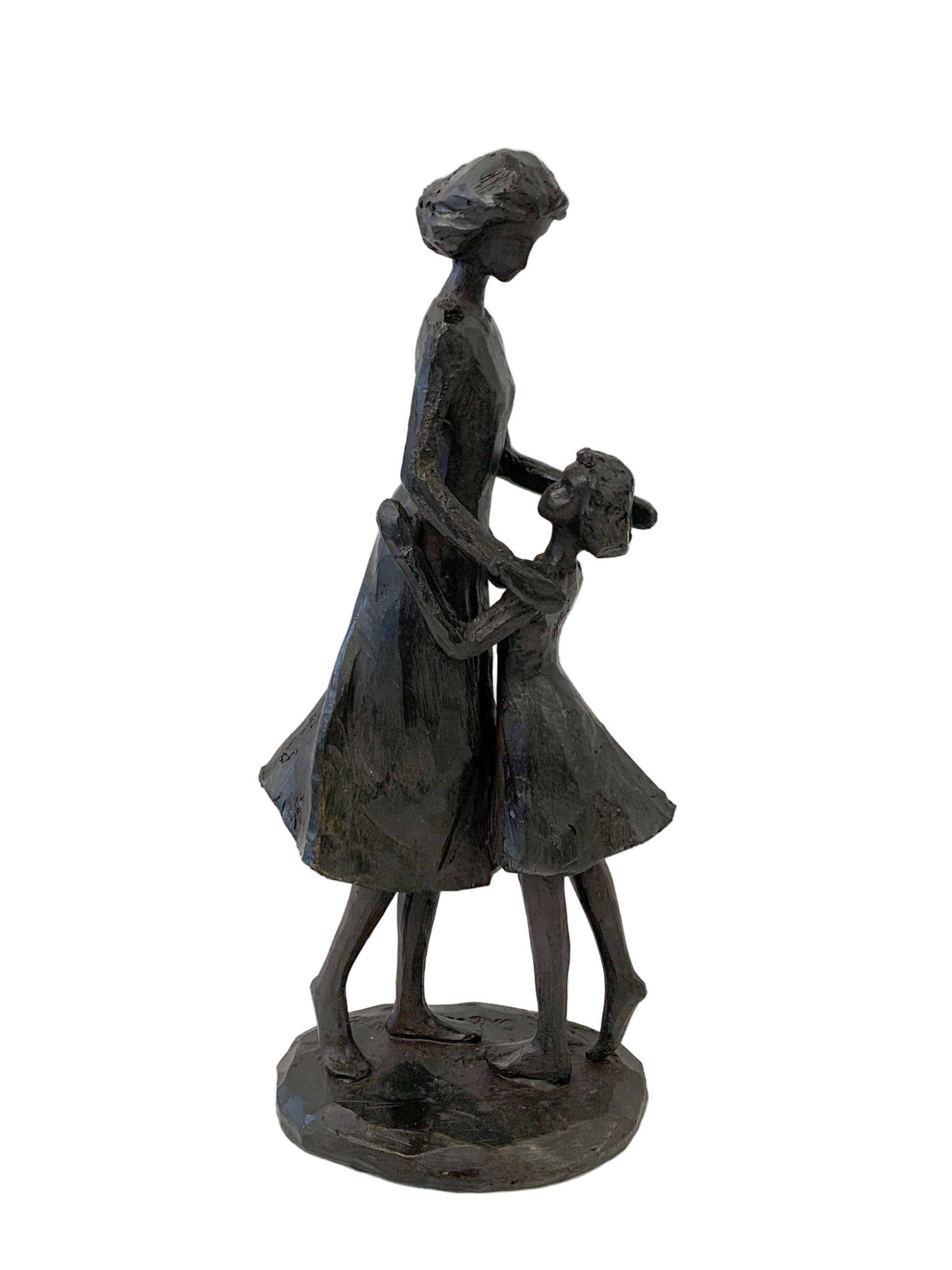 Statue of a mother and daughter dancing on a white background. 